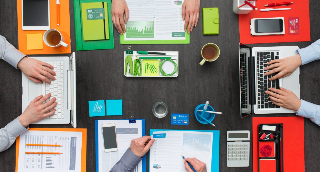 Creative colorful business workspace, business people working together at office desk, flat lay